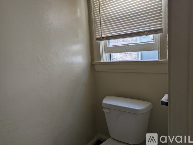A white toilet in a small room with a window.