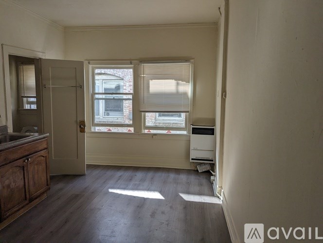 A room with a window and a door is available for rent.