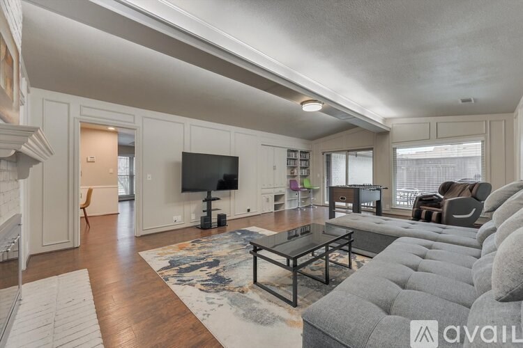 A living room with a grey couch and a black coffee table.