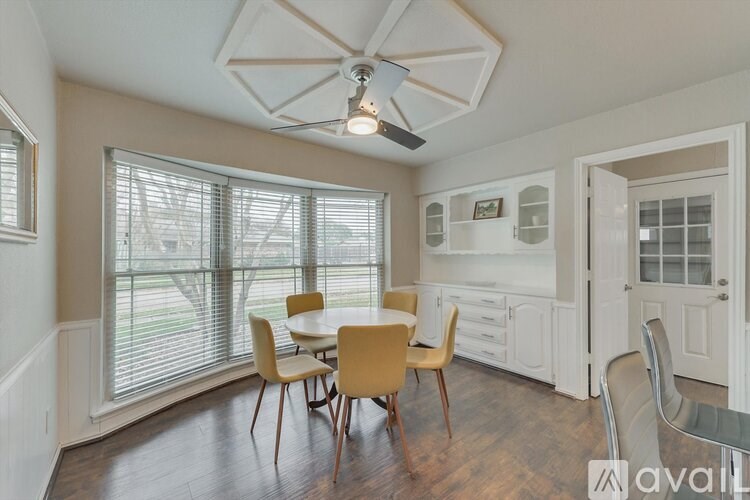 A dining room with a table and chairs.