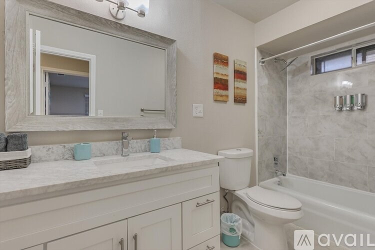 A bathroom with a white toilet, sink, and bathtub.