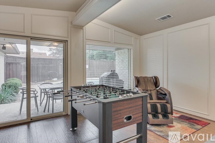 A kitchen with a stove top oven and a dining table outside.