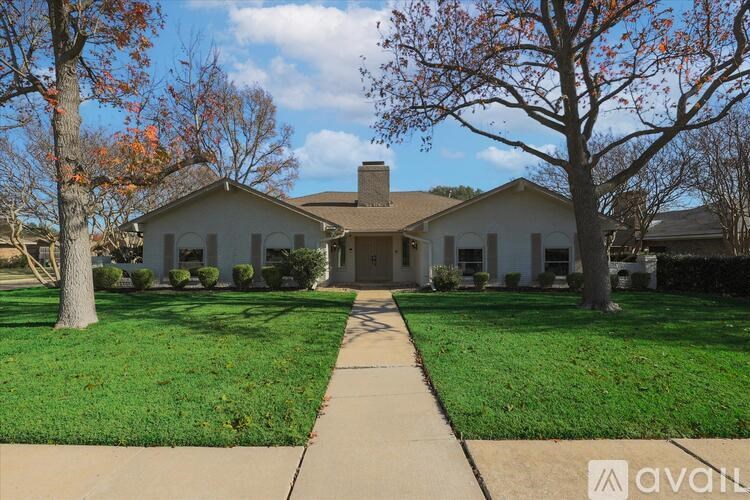 A house with a lawn and trees in front of it.
