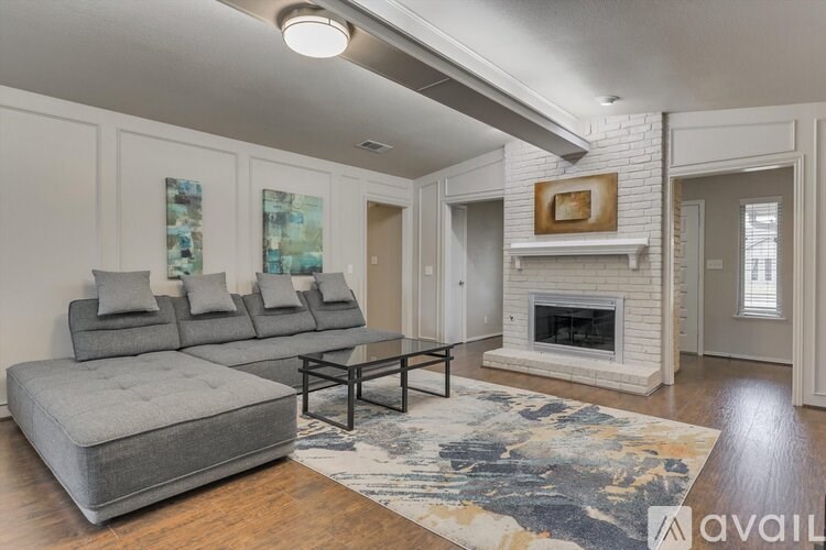 A living room with a grey couch, a coffee table, and a fireplace.