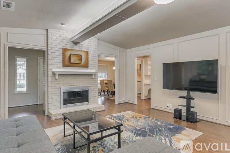 A living room with a fireplace and a grey sofa.