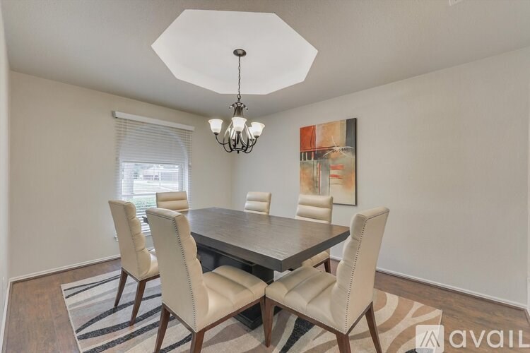 A dining room with a table and chairs and a chandelier.