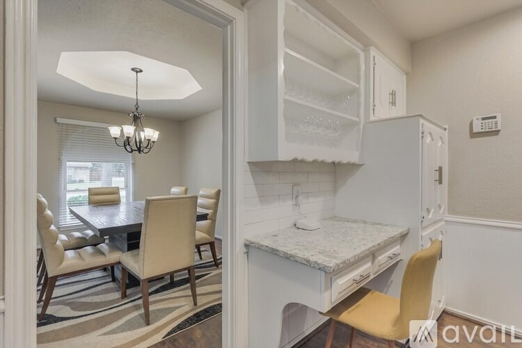 A kitchen with a table and chairs in front of a window.