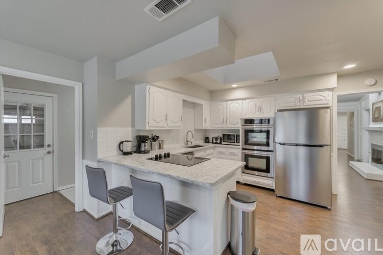 A kitchen with a white countertop and stainless steel appliances.