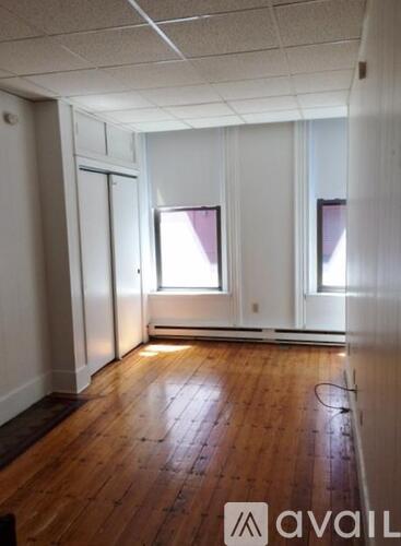 A room with wooden floors and two windows.