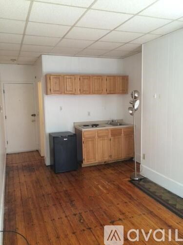 A kitchen with wooden floors and cabinets.