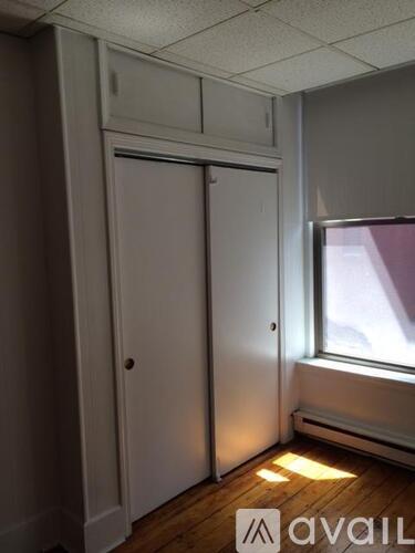 A room with a white door and a window.