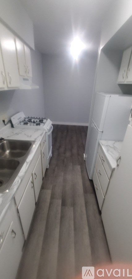 A kitchen with white cabinets and a white fridge.