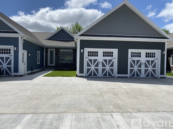 A two-car garage with a blue house in the background.