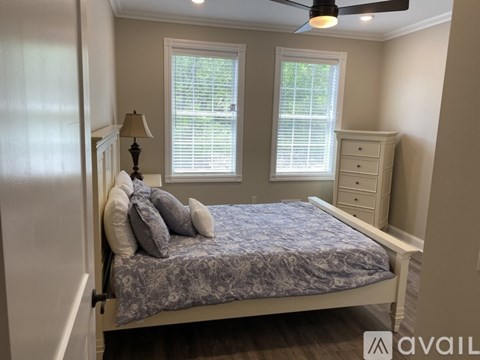 A bedroom with a bed, dresser, and window.