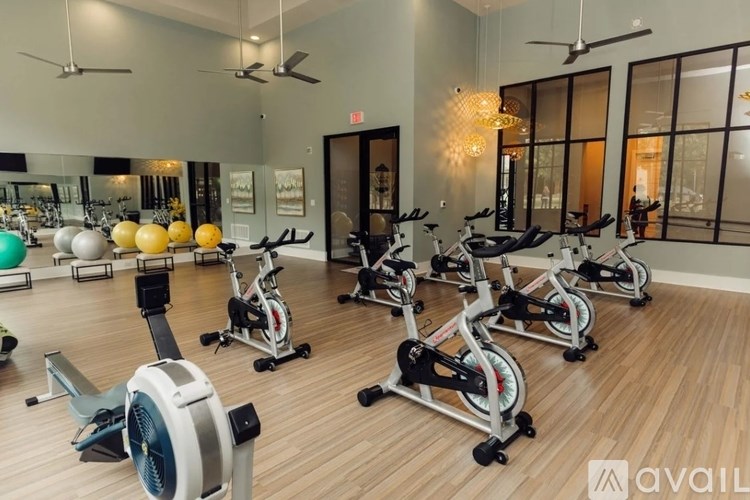 A gym with exercise equipment and mirrors on the wall.