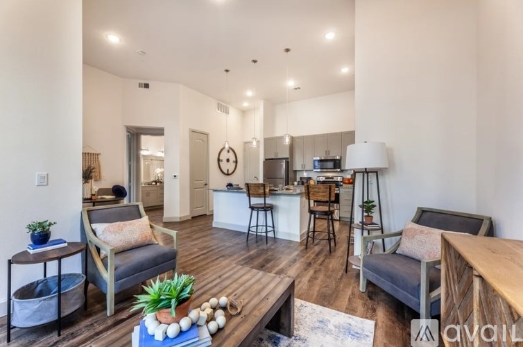 A living room with a grey couch, a wooden table, and a white lamp.