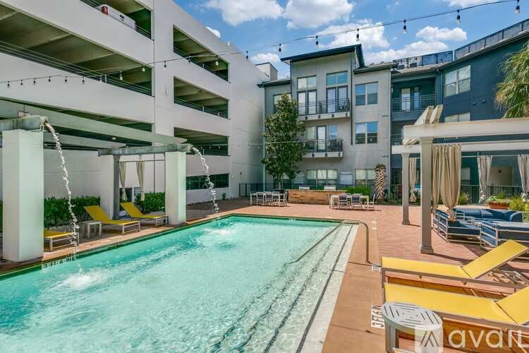 A pool area with yellow sun loungers and a white building in the background.