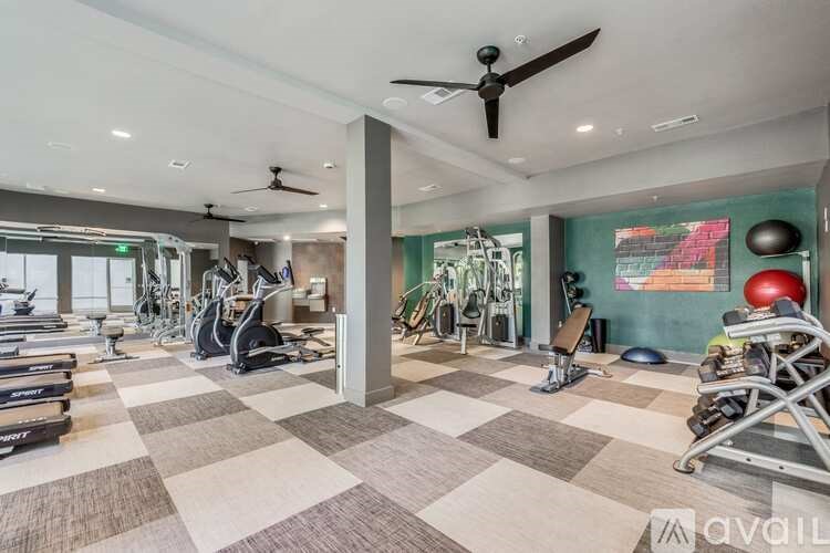 A gym with a variety of equipment including treadmills, stationary bikes, and weight machines.