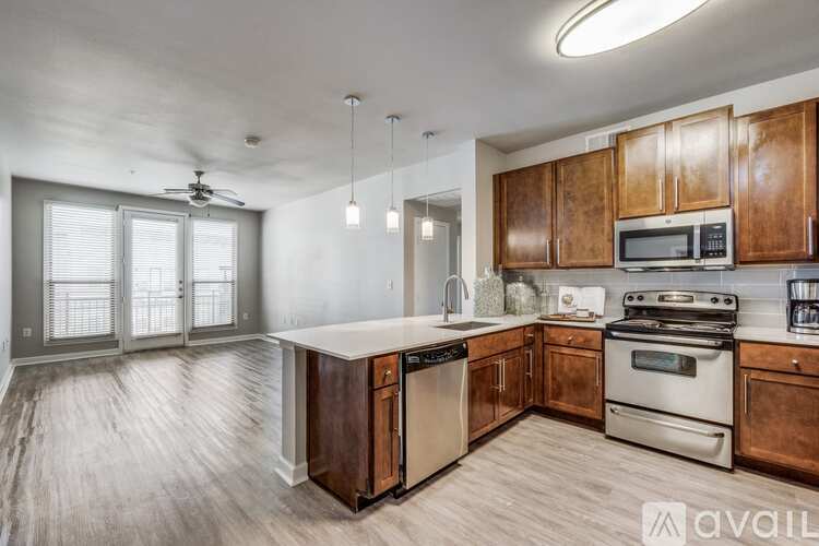 A kitchen with wooden cabinets and stainless steel appliances is available for rent.