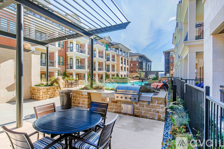A patio with a table and chairs is covered by a roof.