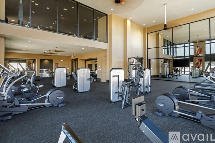 A gym with a variety of equipment including treadmills, weights, and exercise machines.