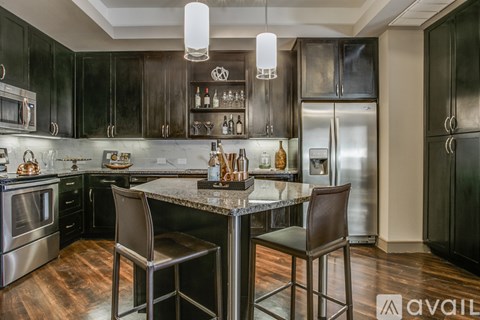 A modern kitchen with dark wood cabinets and stainless steel appliances.