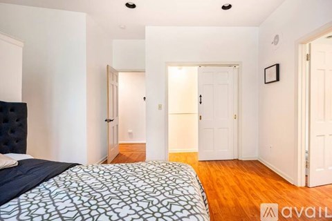 A bedroom with a bed and a wooden floor.