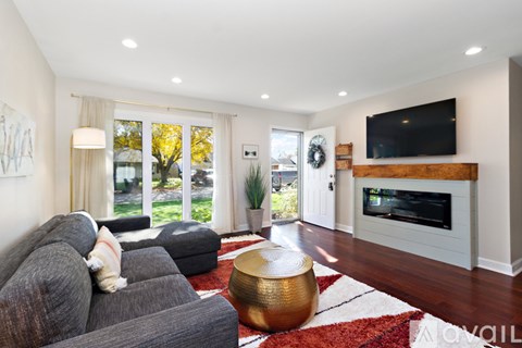 A living room with a grey couch and a television on a wooden stand.