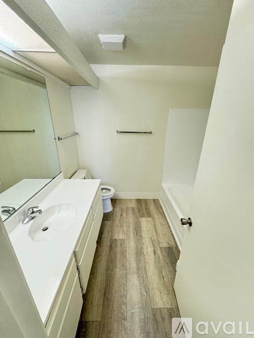A bathroom with a toilet in the corner and a sink with a mirror above it.