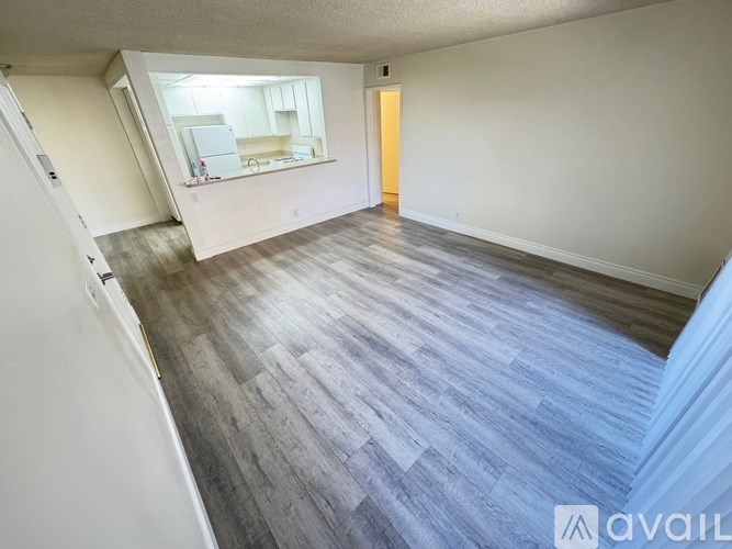 A room with a wooden floor and a mirror on the wall.