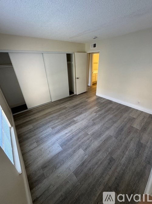 A room with wooden flooring and white walls.