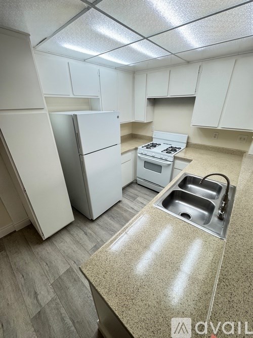 A kitchen with white appliances and cabinets.