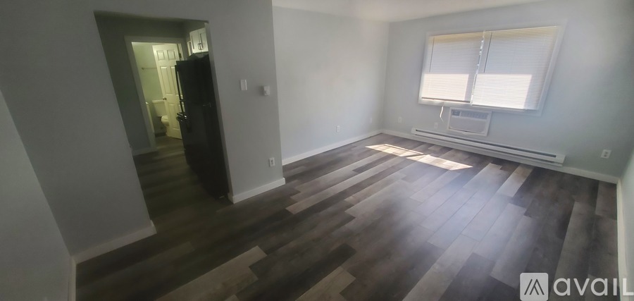 A room with wooden flooring and a sliding glass door.