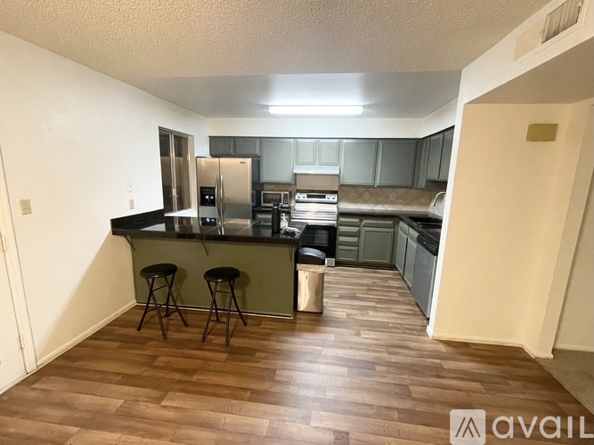 A kitchen with a bar area and stools.