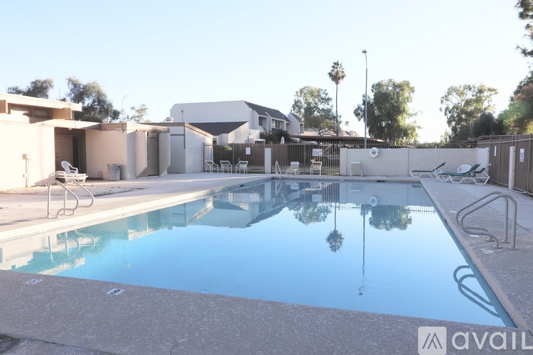 A pool with a reflection of a tree and a building.