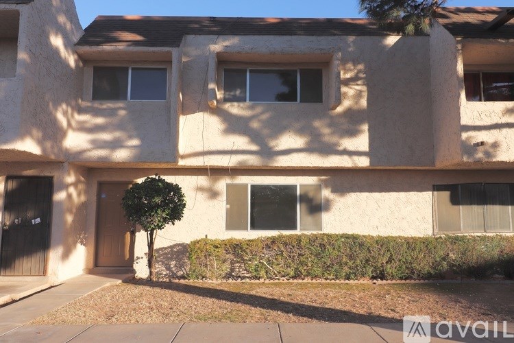 A beige building with a tree in front of it.