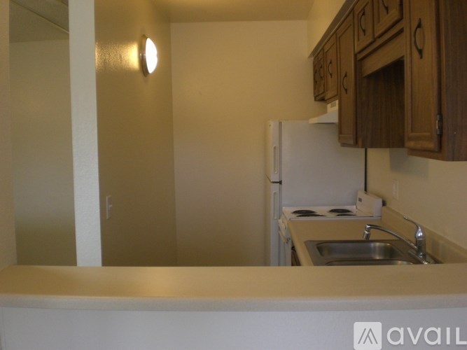 A kitchen with a white refrigerator and wooden cabinets.