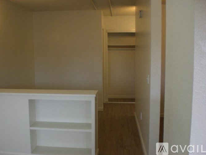 A white shelf unit sits in a narrow hallway.
