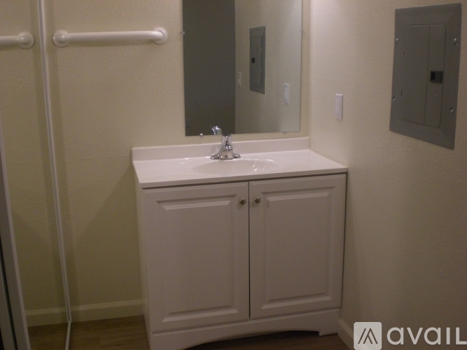 A bathroom with a sink, mirror, and cabinets.