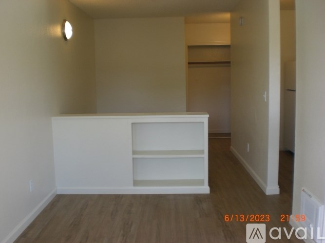 A room with a white cabinet and wooden floor.