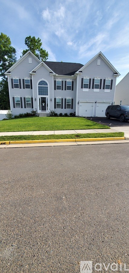 A house with a white exterior and a black roof is shown.