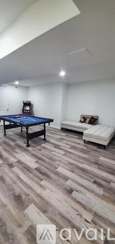 A room with a pool table and a couch.