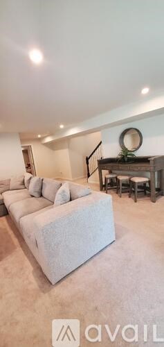 A living room with a white couch and a mirror on the wall.