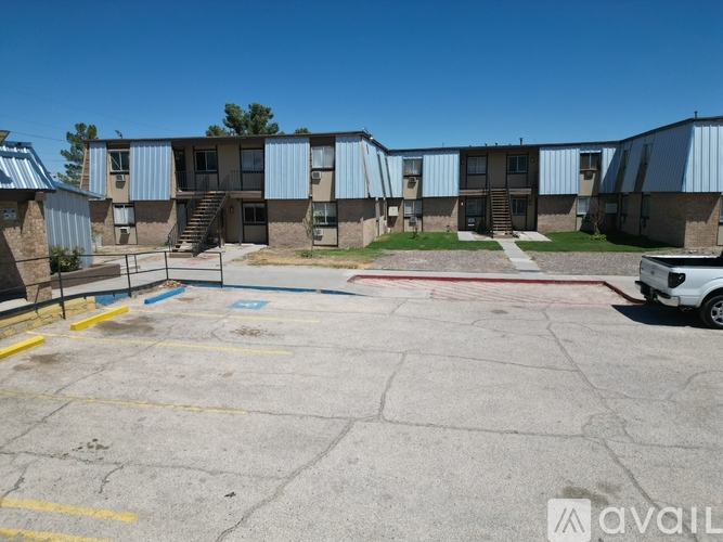 A parking lot in front of a building with a car parked on the right side.