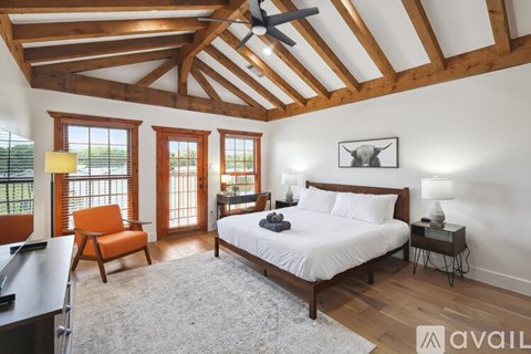 A bedroom with a large bed and a ceiling fan.