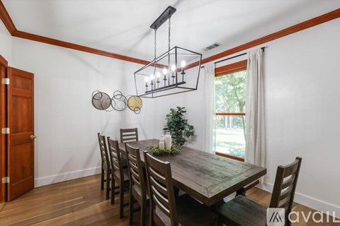 A dining room with a wooden table and chairs.