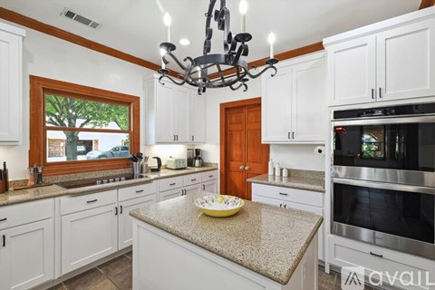 A kitchen with white cabinets and a granite countertop.