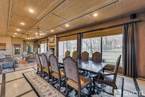 A dining room with a long table and chairs.
