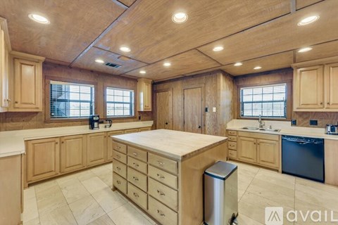 A kitchen with wooden cabinets and a large island.