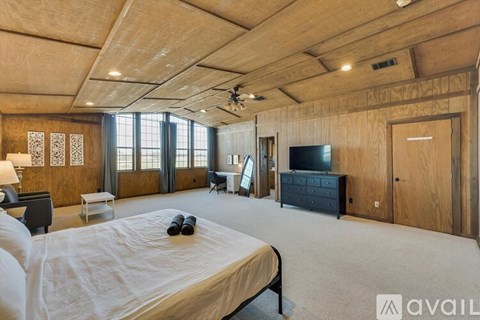 A bedroom with a large bed and a flat screen TV.